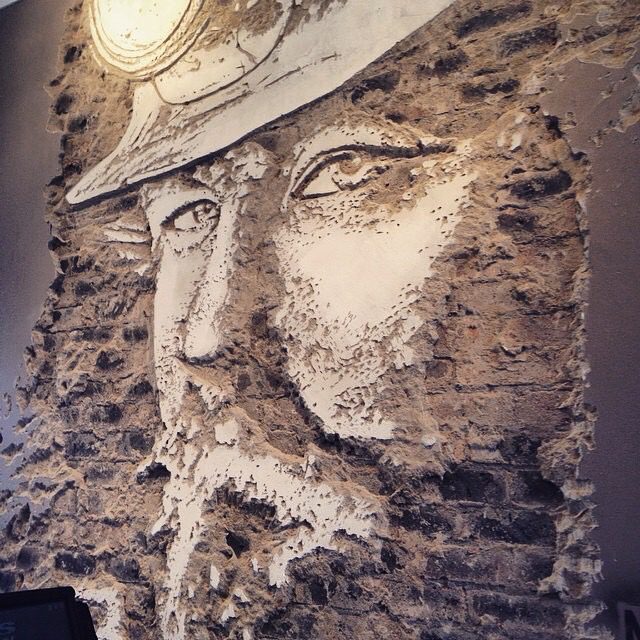 Sculptural face artwork created using textured plaster relief